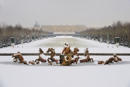 France, Yvelines (78), parc du château de Versailles sous la neige, classé Patrimoine Mondial de l'UNESCO, le bassin d'Apollon par Tuby avec le char d'Apollon et l'axe du Soleil vers le château