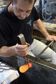 France, Moselle, Meisenthal, Centre international d'Art verrier (CIAV) (international glass centre), the blowing workshop, crafting a Christmas ball, the prompter and master glassmaker Jean-Marc Schiltregulates the mass at home plate while performing a continuous rotation of his cane and preparation of the parison before passing to the mold