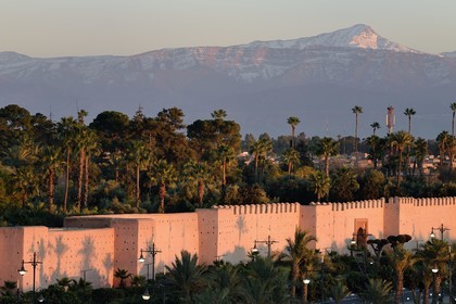 Morocco, High Atlas, Marrakech, Imperial city, Medina listed as World Heritage by UNESCO, the ramparts of the city and the Oukaïmeden summit in the snow-covered Atlas in the background at sunset