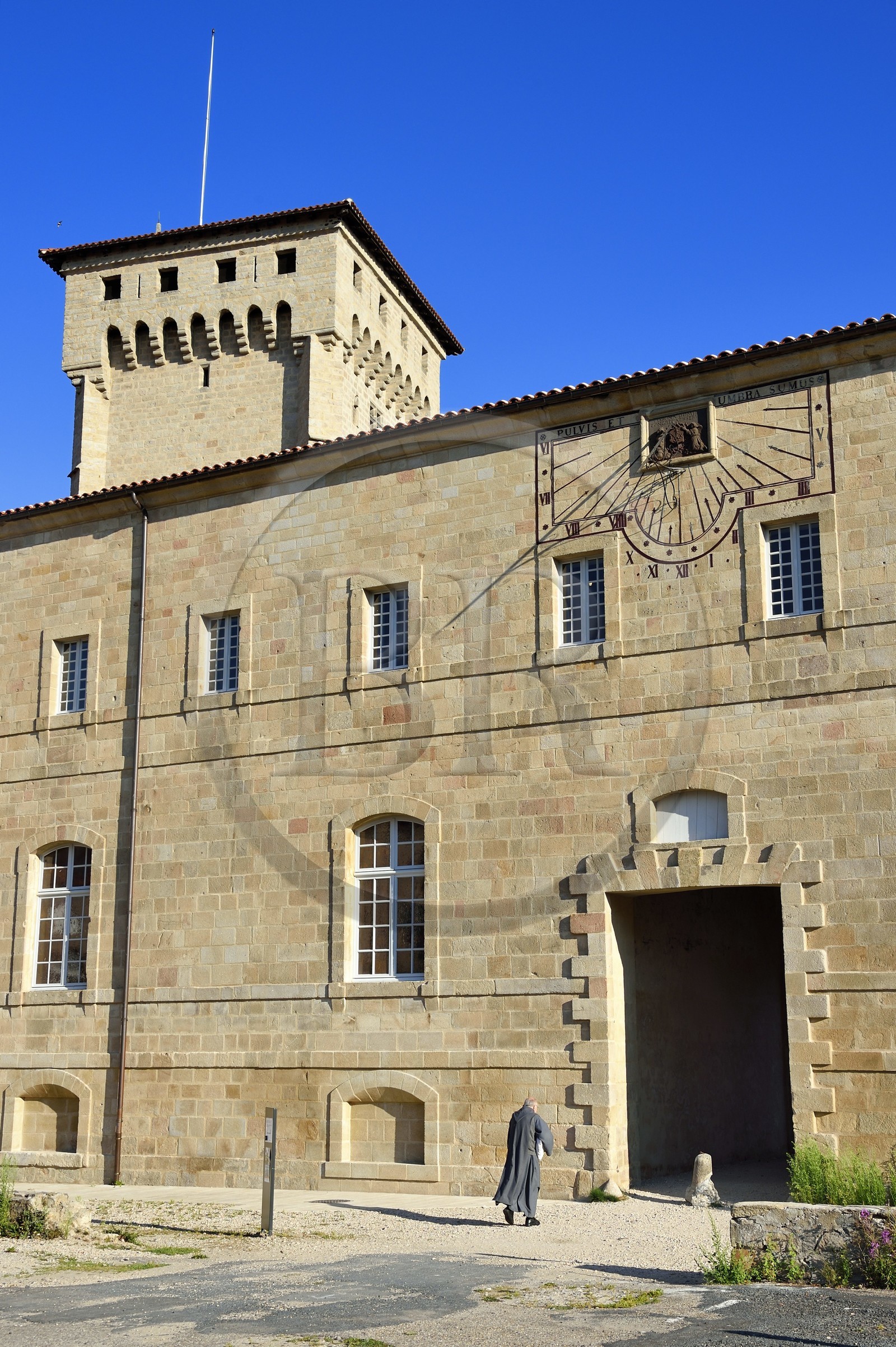 France, Haute Loire, Livradois Forez Regional Natural Park (Parc naturel régional Livradois-Forez), the Chaise-Dieu abbey, a brother of Saint John entering the abbey, the Clementine tower in the background