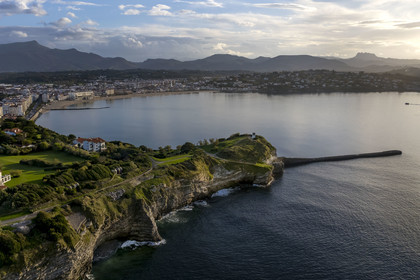 France, Pyrenees Atlantiques, Basque Country coast, Saint-Jean-de-Luz, the coastal path on the GR 8 passing over the flysch cliff of Pointe Sainte-Barbe, a sort of mille-feuille alternating hard and soft rocks, the bay of Saint-Jean-de-Luz and the Pyrenees in the background (aerial view)
