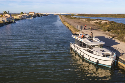 France, Hérault (34), Frontignan, bateau de plaisance Le Boat sur le canal du Rhône à Sète, le pont de la plage des Aresquiers en arrière plan (vue aérienne)