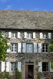 France, Cantal, Parc Naturel Régional des Volcans d'Auvergne (regional nature park of Auvergne volcanoes), step on the Way of St. James to Santiago de Compostela by Via Arverna, Chalinargues, Mons hamlet, the stone cross surmounting the roof of the houses covered with lauze is one of the main traditional themes of protection