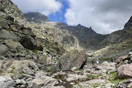 France, Alpes-Maritimes (06), parc national du Mercantour, Vallée des Merveilles parsemée de milliers de gravures rupestres de l'Age de bronze, randonneurs sur le sentier de randonnée GR 52 au lac des Merveilles en contrebas de la Baisse de Valmasque et le Mont du Grand Capelet (2915m) en arrière plan à gauche