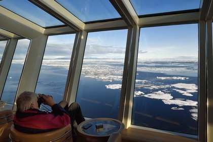 Greenland, North West coast, Smith sound north of Baffin Bay, Hurtigruten's MS Fram cruse ship, passenger watching the Arctic sea ice from the panoramic room