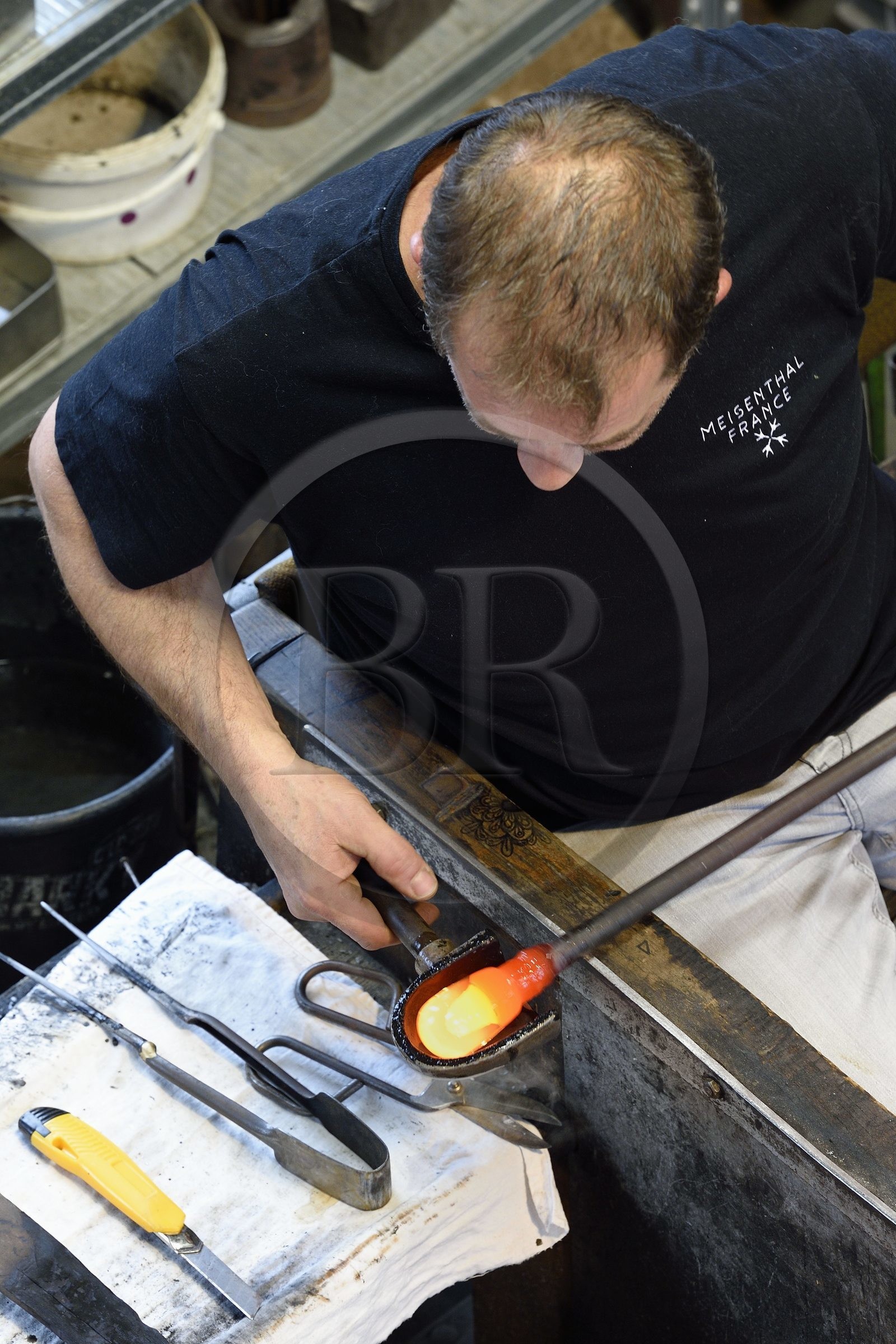 France, Moselle (57), Meisenthal, Centre international d’Art verrier (CIAV), l'atelier de soufflage, fabrication artisanale d'une boule de Noël, le souffleur régularise la masse au marbre tout en effectuant une rotation continue de sa canne