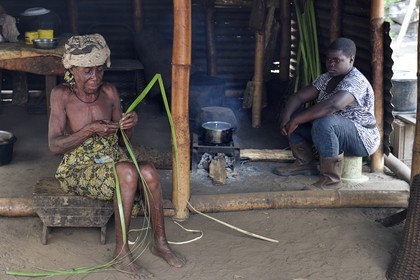 Gabon, province de Ogooué- Maritime, région de Omboué, Nengeue Sika (ile d’argent) dans la lagune Fernan Vaz (Nkomi), vieille femme préparant une tresse dans sa case