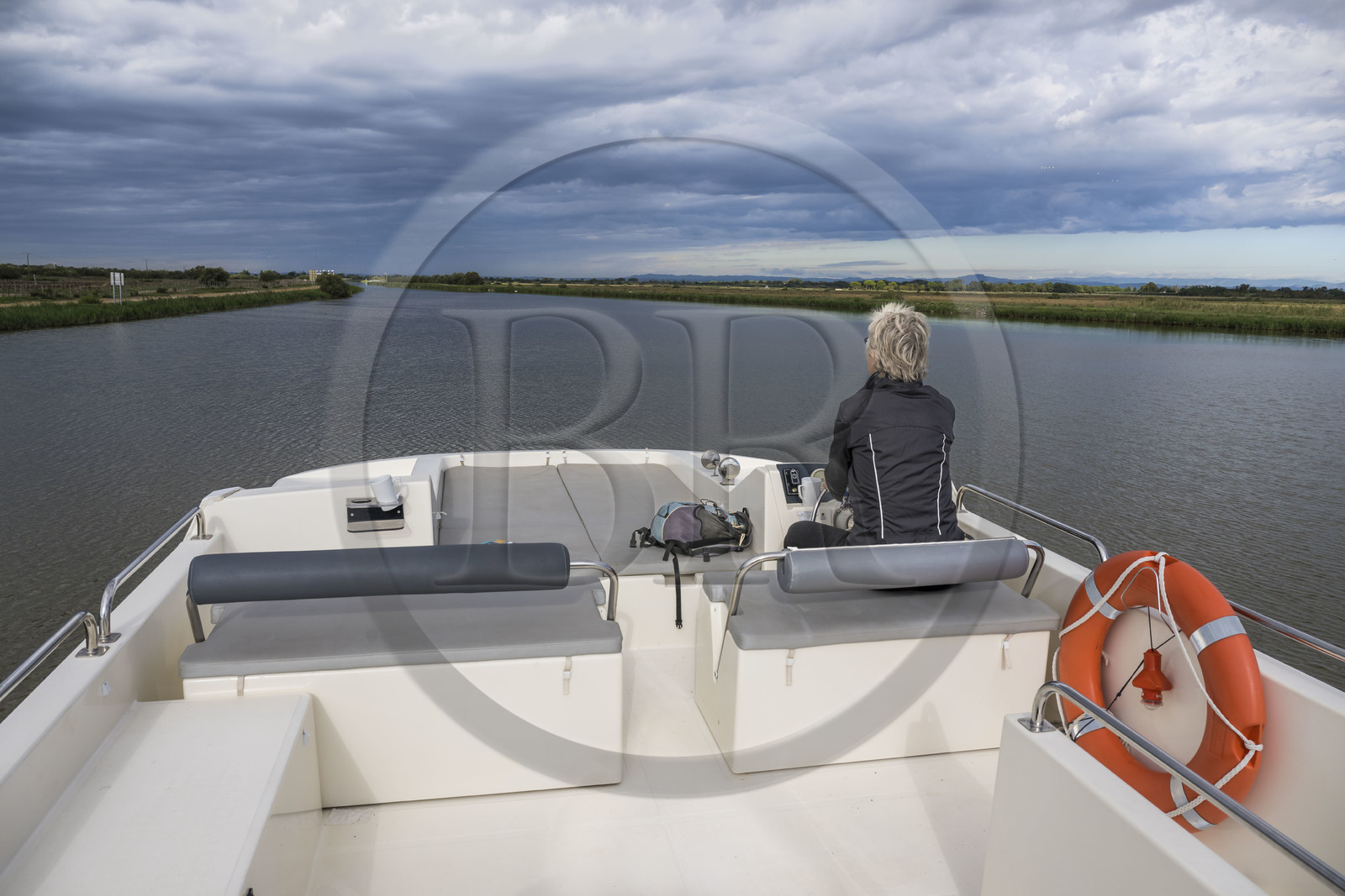 France, Gard (30), Aigues-Mortes, navigation d'un bateau de plaisance Le Boat sur le canal du Rhône à Sète à la sortie de la ville, les Portes de Vidourle en arrière plan