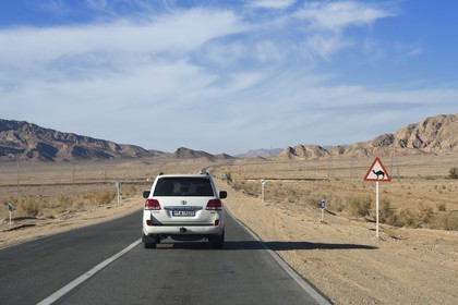 Iran, Isfahan province, Dasht-e Kavir desert, Toyota Land Cruiser 4x4 on Highway 62 from Nain to Khur, Camel Crossing Sign, camels are responsible for many road accidents especially at night