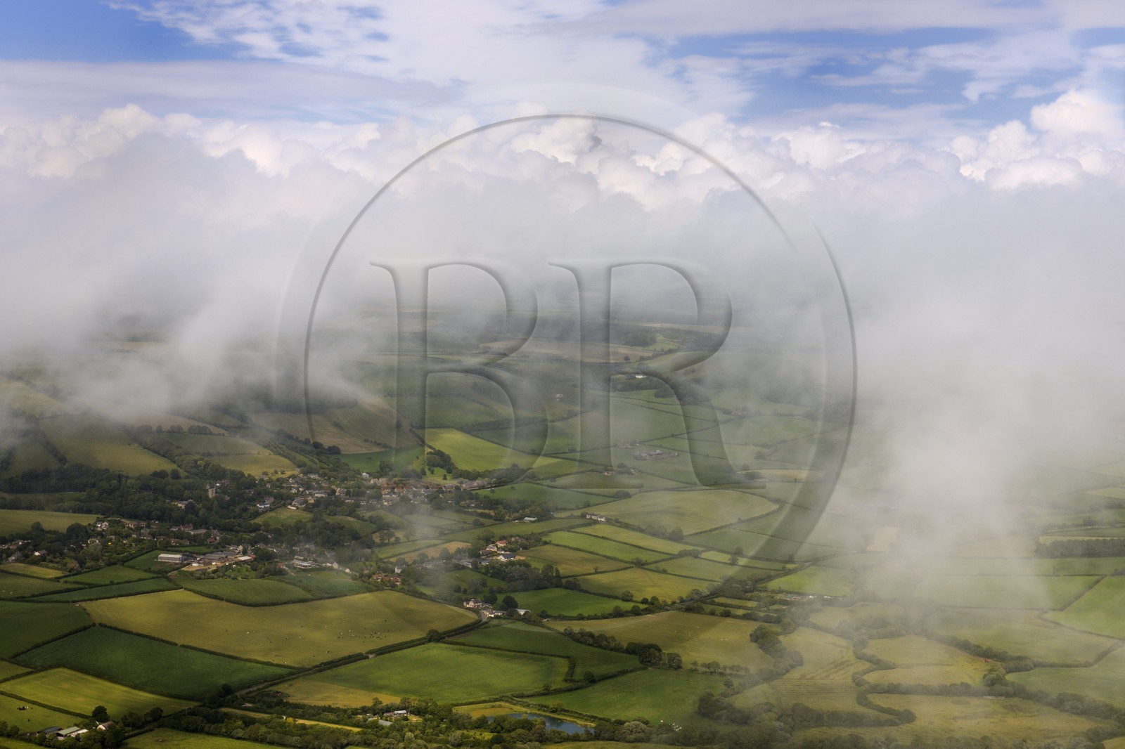 United Kingdom, England, Dorset, the village of Litton Cheney in the clouds surrounded by fields (aerial view)
