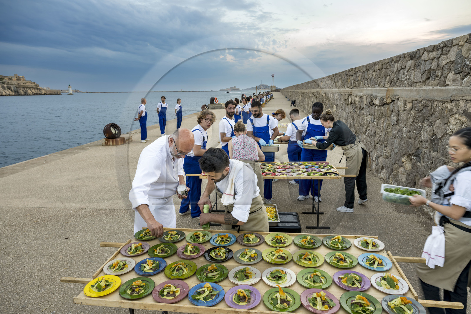 France, Bouches-du-Rhône (13), Marseille, Zone Euroméditerranée, grand port maritime de Marseille (GPMM), la digue du large, convives attablés à une grand table de banquet dressée par le chef Emmanuel Perrodin dans le cadre des Diners Insolites, derniers préparatifs au plats