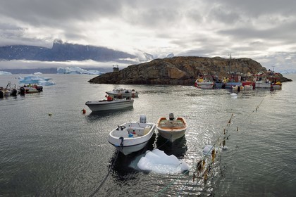 Groenland, cote ouest, fjord de Uummannaq, bateaux pour la pêche et la chasse, icebergs à la sortie du port