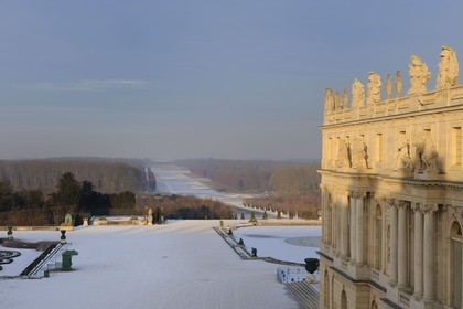 France, Yvelines (78), parc du château de Versailles sous la neige, classé Patrimoine Mondial de l'UNESCO, le château et la perspective des jardins et de l'axe du Soleil vers le Grand Canal gelé
