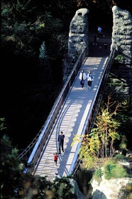 France, Paris, walking on the suspension bridge of the Buttes Chaumont park