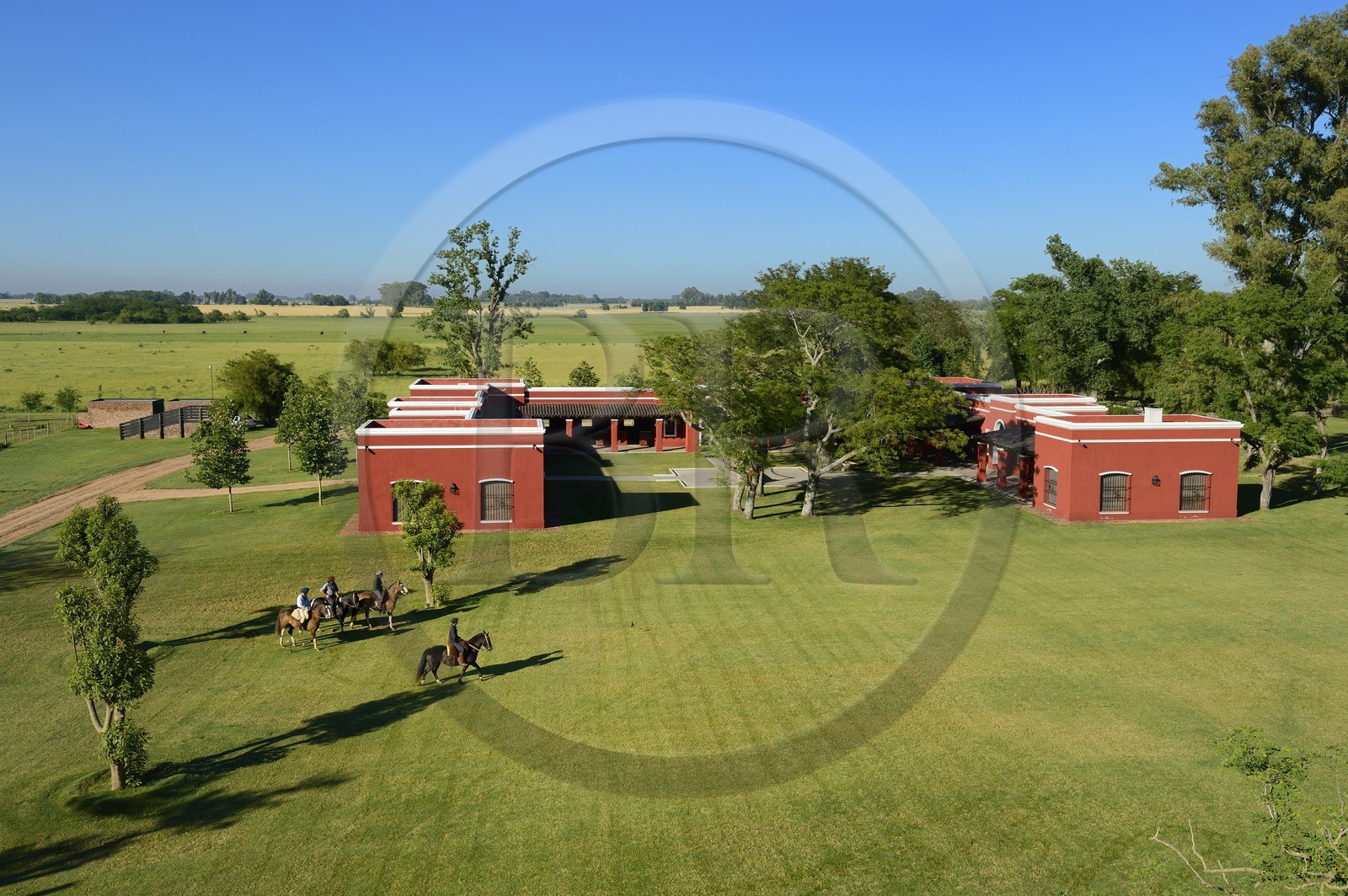 Argentine, province de Buenos Aires, San Antonio de Areco, estancia La Bamba de Areco, gauchos à cheval passant devant l'étable des chevaux utilisés pour le polo