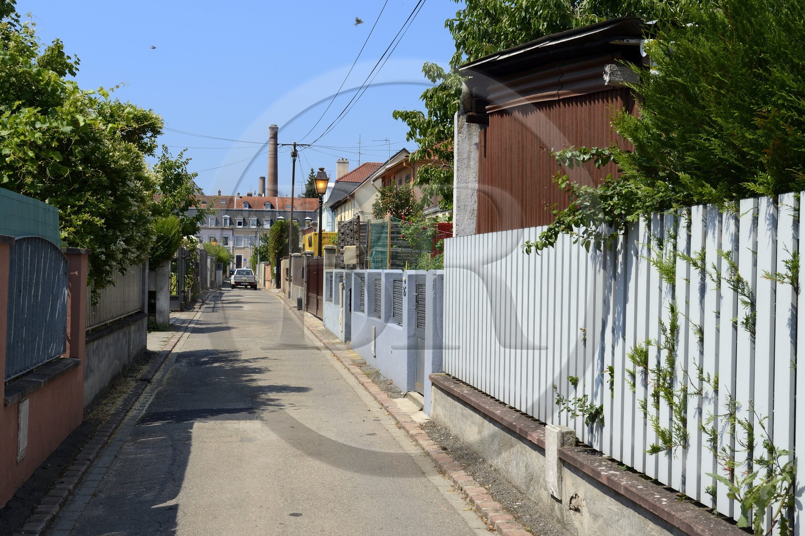 France, Haut-Rhin (68), Mulhouse, la Cité ouvrière, passage des Corbeaux et cheminées en brique de l'entreprise textile DMC (Dollfus-Mieg et Compagnie) en arrière plan