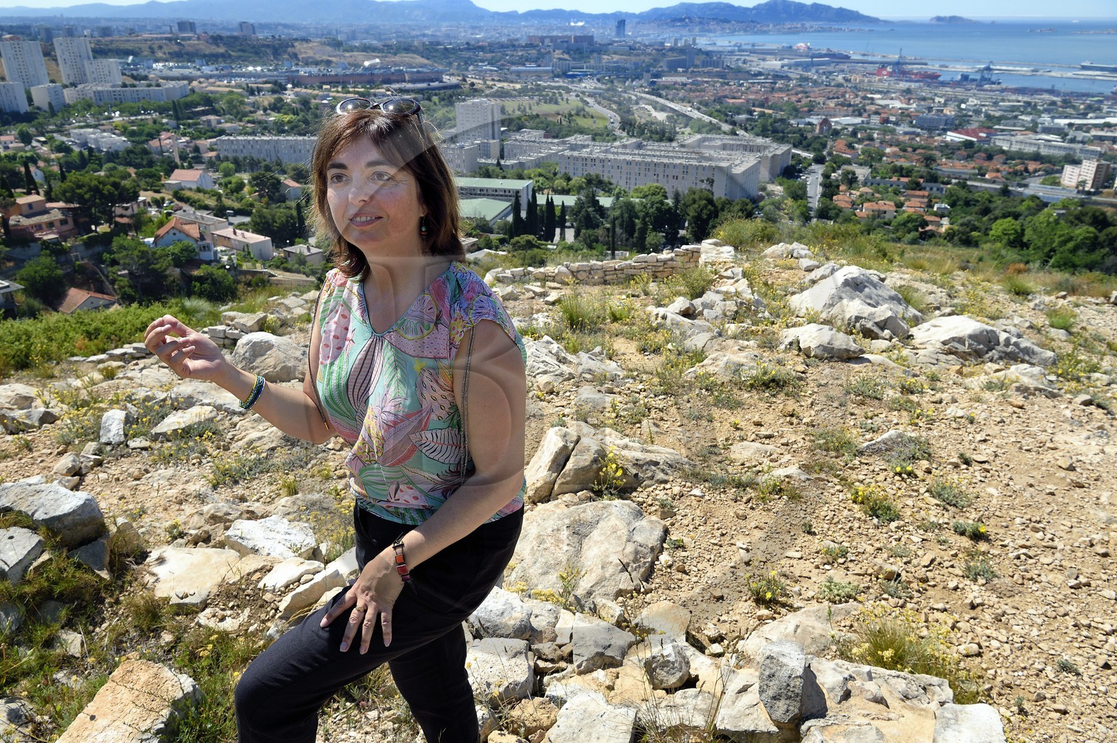 France, Bouches-du-Rhône (13), Marseille, les quartiers Nord, site archéologique celto-ligure de l'oppidum de Verduron fondé à la fin du IIIe siècle av. J.-C au premier plan, la Cité Castellane et le Grand Port Maritime en arrière plan, l'archeologue Nathalie Cazals