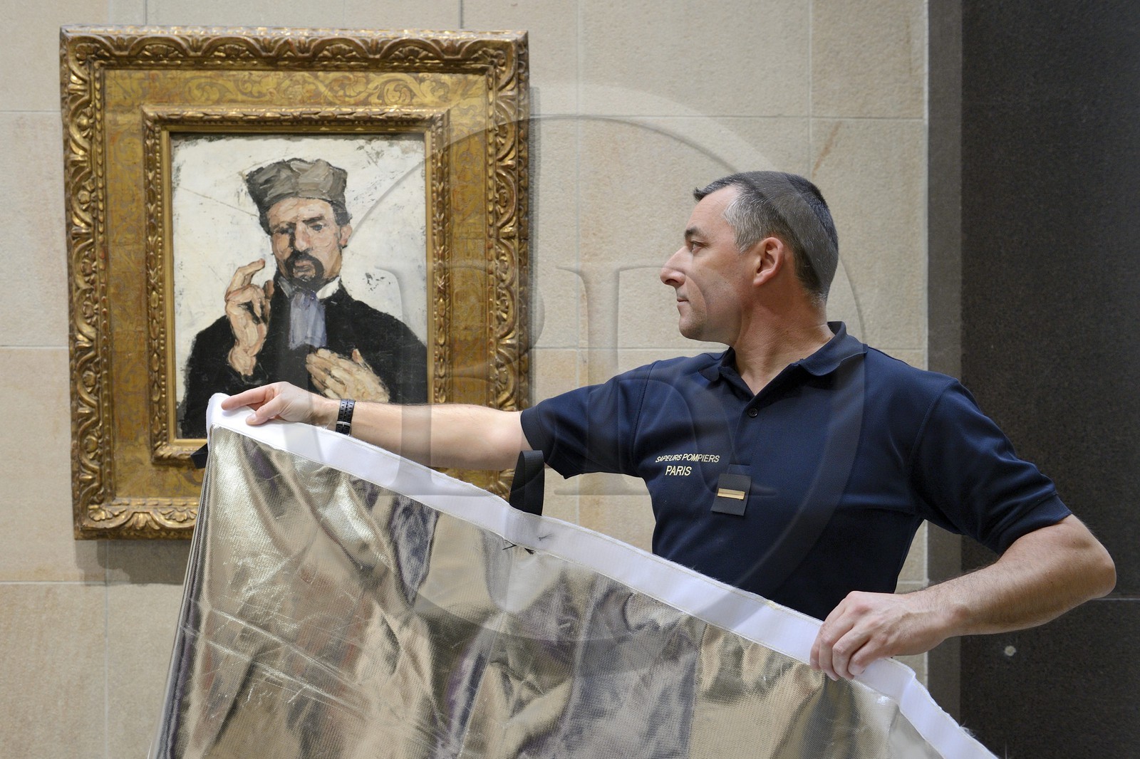 France, Paris (75), musée d'Orsay, le pompier adjudant-chef Xavier Trémeau utilisant une bâche spécialement conçue pour la protection des oeuvres d'art en cas de sinistre, Paul Cézanne (1839-1906) L'avocat