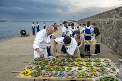 France, Bouches-du-Rhône (13), Marseille, Zone Euroméditerranée, grand port maritime de Marseille (GPMM), la digue du large, convives attablés à une grand table de banquet dressée par le chef Emmanuel Perrodin dans le cadre des Diners Insolites, derniers préparatifs au plats