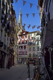 France, Pyrenees Atlantiques, Basque Country, Bayonne, traditional houses rue Argenterie and the spires of St. Catherine's Cathedral in the background