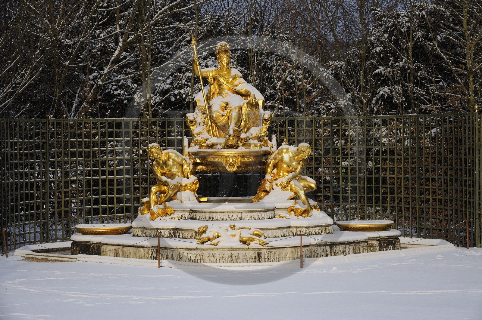 France, Yvelines, snow covered park of the Chateau de Versailles, listed as World Heritage by UNESCO, statue of the Triumphal Arch Grove