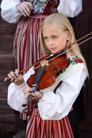 Suède, comté de Dalécarlie, région de Leksand, célébrations du solstice d'été dans le petit hameau de Hjulbäck, jeune fille en costume traditionnel jouant du violon