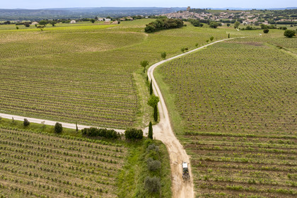 France, Vaucluse (84), Châteauneuf-du-Pape, tracteur viticole sur le chemin Coste Froide sur le plateau de la Crau et le donjon de Châteauneuf-du-Pape en arrière plan (vue aérienne)