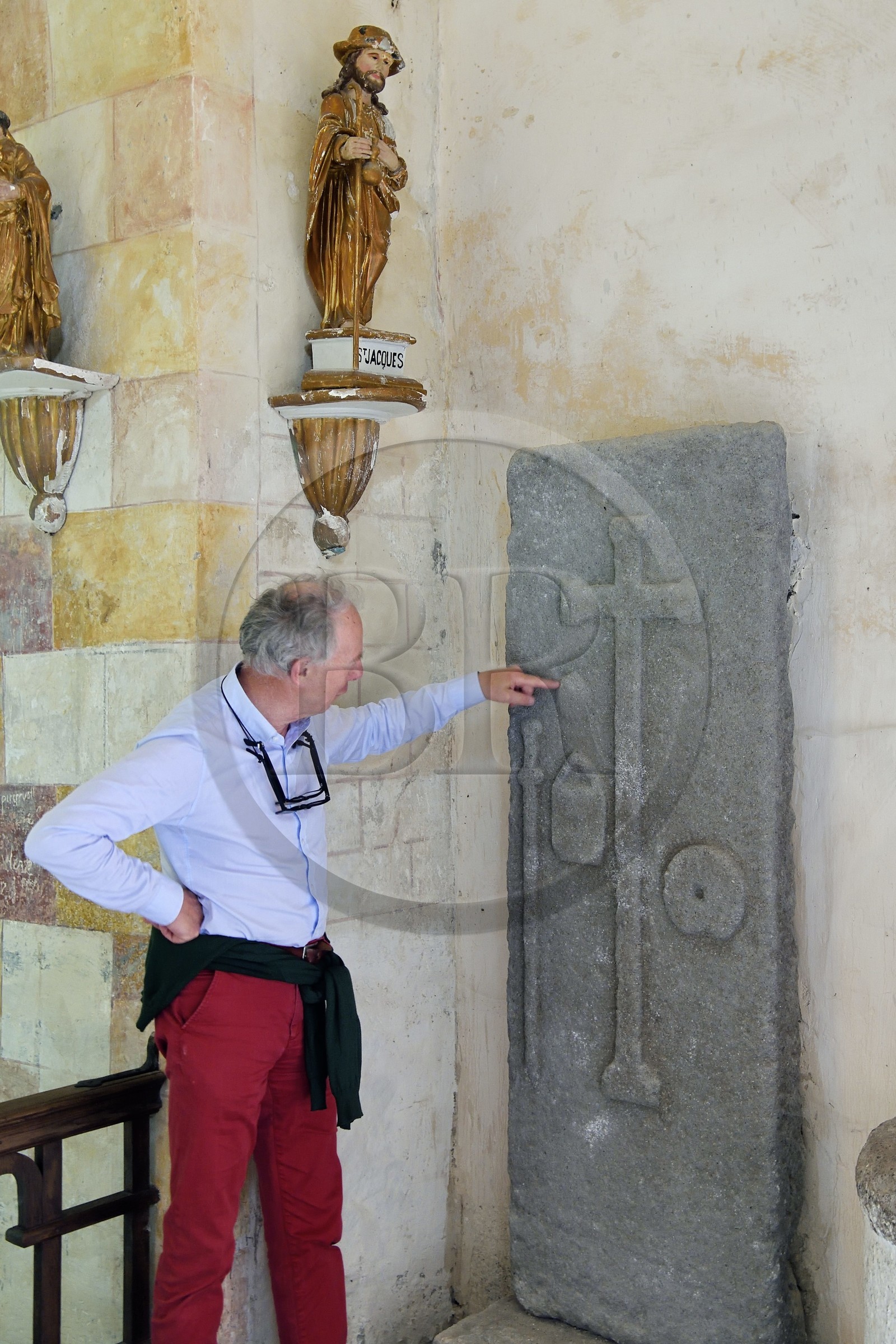 France, Cantal, step on the Way of St. James to Santiago de Compostela by Via Arverna, Neussargues-Moissac, 12th century Saint-Hilaire church, tomb of a 17th century pilgrim who made the way to St Jacques de Compostela, tombstone with the bumblebee, the sack and the shell around the funeral cross, the chief heritage curator Humbert Jacomet