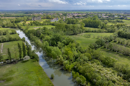 France, Vendée (85), Parc Interrégional du Marais Poitevin labellisé Grand Site de France, Maillezais, parcelles de terres entrecoupées par les affluents de l'Autise, les vestiges de l'abbaye Saint-Pierre de Maillezais en arrière plan (vue aérienne)
