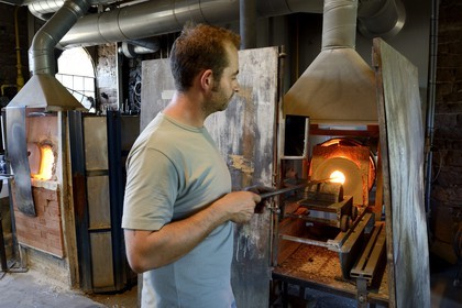 France, Moselle (57), Meisenthal, souffleur de verre au Centre international d'Art verrier (CIAV), récupération du verre chaud dans un four par un souffleur