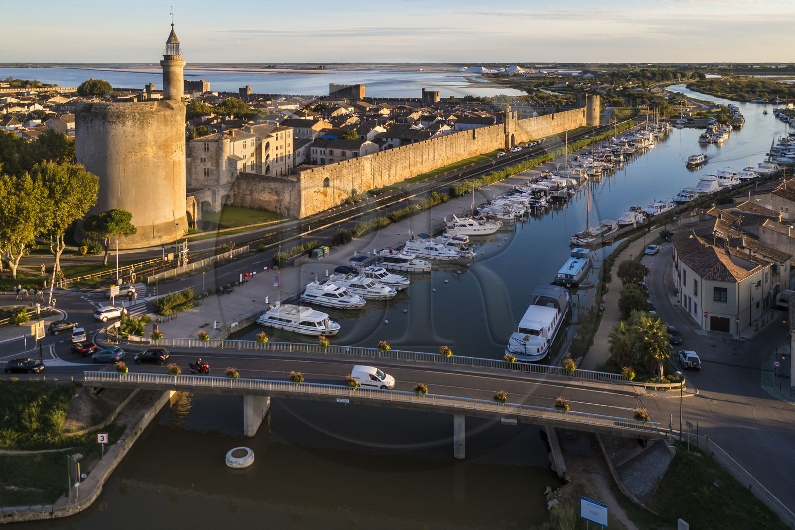 France, Gard (30), Aigues-Mortes, la ville médiévale entourée par ses remparts, la Tour de Constance et le port du canal du Rhône à Sète au premier plan, les marais salants (Salins du Midi) en arrière plan (vue aérienne)
