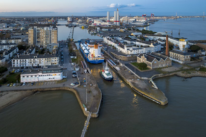 France, Loire Atlantique, Saint Nazaire, The General Cargo Rotra Mare transports sections of wind turbine masts and enters the port's wet dock (in the background) via the south lock, which was also the site of Operation Chariot launched in 1942 by the British (aerial view)