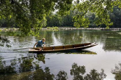 France, Vaucluse, L'Isle sur la Sorgue, François Arnaud member of the brotherhood of fishermen the Pescaïres de la Sorgue sailing on the Sorgue river on a flat-bottomed boat called Nègo Chin