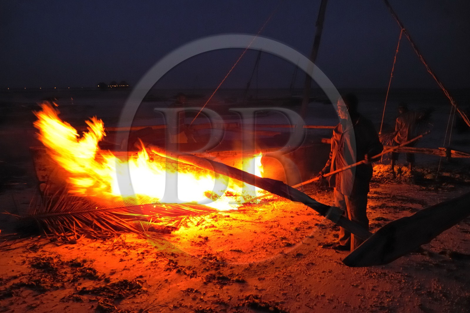 Tanzanie, archipel de Zanzibar, île de Unguja (Zanzibar), côte Sud-Est, Bwejuu, pêcheurs brûlant les algues sur un dhow (boutre traditionnel)