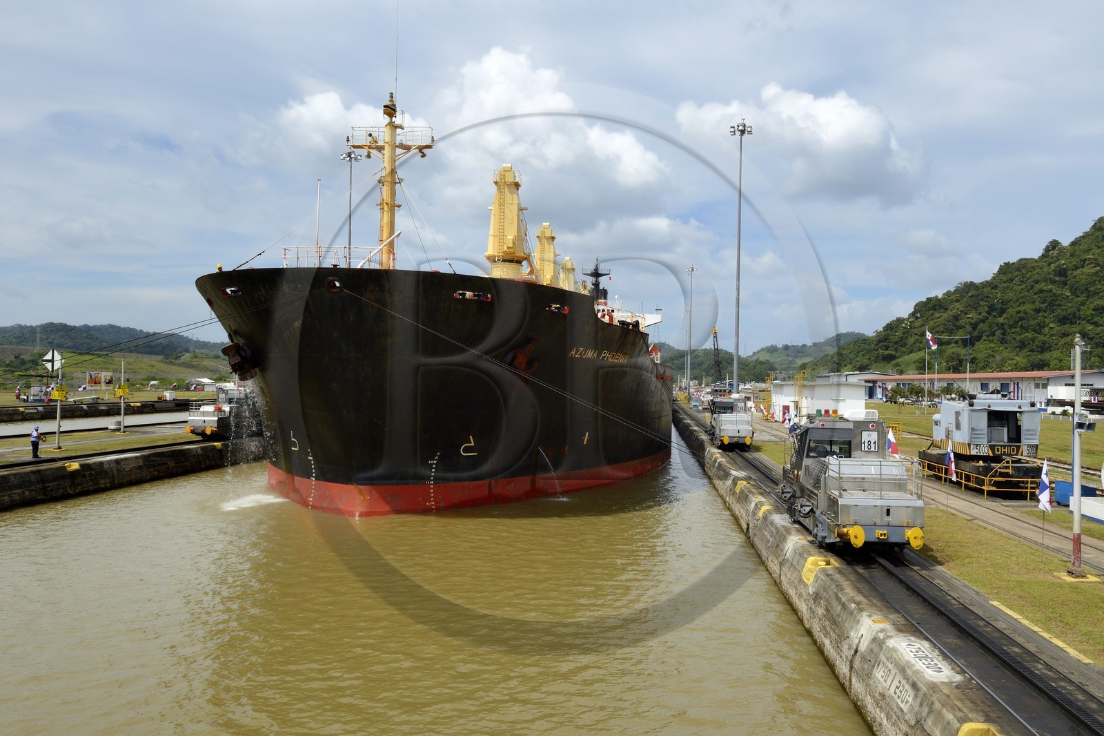 Panama, Canal de Panama, écluses de Pedro Miguel, mules mécaniques ou locomotives électriques guidant un cargo Panamax entre les murs de l'écluse