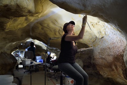 France, Dordogne (24), Montignac, chantier du futur Centre International de l'Art pariétal de Montignac-Lascaux (Lascaux 4), l'abside de la grotte reconstituée par l’Atelier des Fac-Similés du Périgord (AFSP) et le passage en arrière plan, réalisation des jointures des panneaux de surfaces ornées par la peintre Catherine Gout