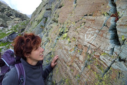 France, Alpes-Maritimes (06), parc national du Mercantour, vallée des Merveilles parsemée de milliers de gravures rupestres de l'Age de bronze, l'archéologue Nicoletta Bianchi étudie la figure corniforme anthropomorphisée gravée sur la roche dite du Christ