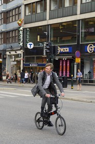 Suède, Stockholm, homme en costume sur une bicyclette pliable