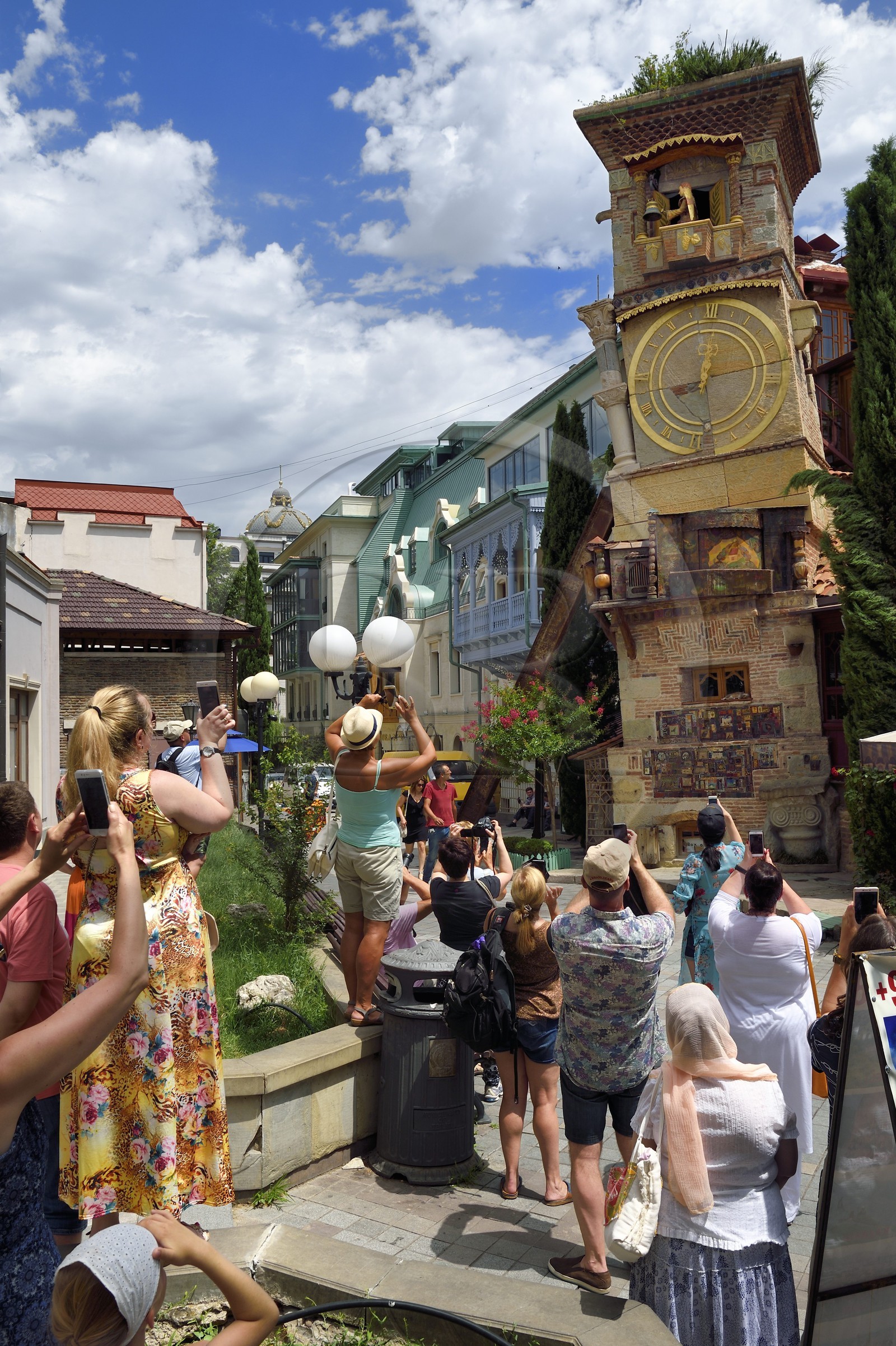 Géorgie, Tbilissi, vieille ville, touristes devant tour de l'horloge du Théâtre de marionnettes dédié à Rezo Gabriadze