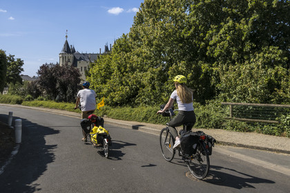 France, Maine-et-Loire (49), vallée de la Loire classée au Patrimoine Mondial par l'UNESCO, Saumur, randonnée à bicyclette sur les berges de la Loire, vélo avec une remorque transportant le matériel de camping, le chateau en arrière plan