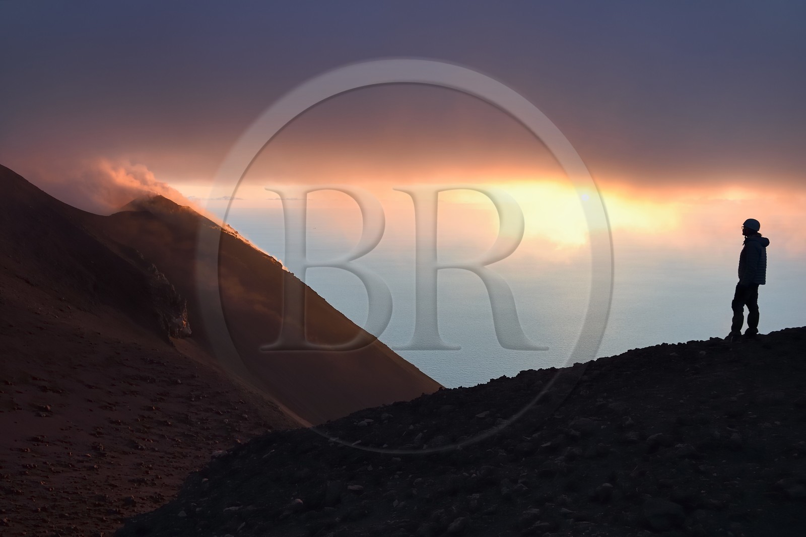 Italy, Sicily, Aeolian Islands, listed as World Heritage by UNESCO, Stromboli island, hiker watching the fumaroles of an eruption on the slopes of the active volcano at sunset