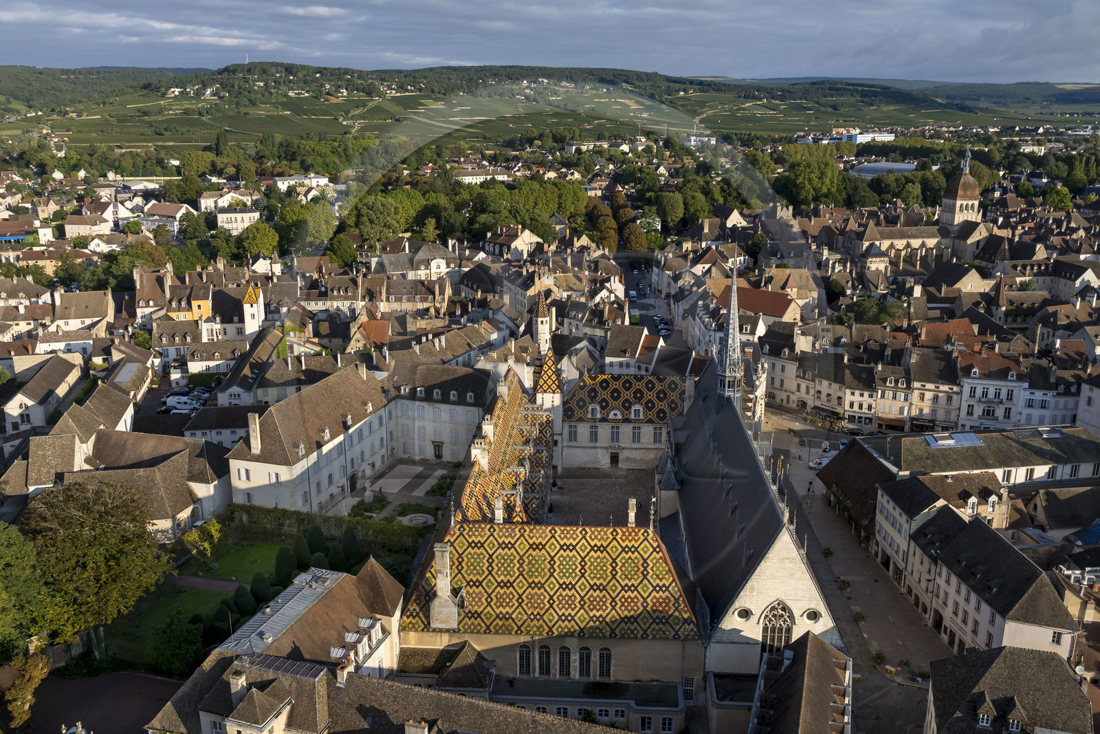 France, Cote d'Or, Beaune, area listed as World Heritage by UNESCO, Hospices de Beaune, Hotel Dieu, the Notre-Dame de Beaune collegiate basilica and the Côte de Beaune in the background (aerial view)