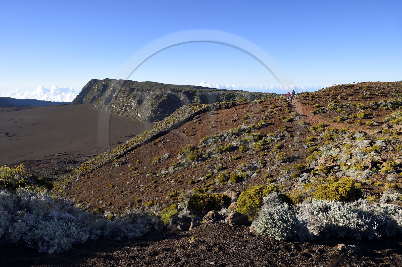 France, Reunion island (French overseas department), Reunion National Park listed as World heritage by UNESCO, on the slopes of the Piton de la Fournaise volcano, hikers on the Ste Therese oratory trail above the Plaine des Sables that we can see below