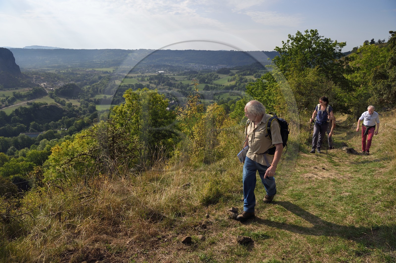 France, Cantal, hikers on the Way of St. James to Santiago de Compostela by Via Arverna overlooking the village of Neussargues-Moissac
