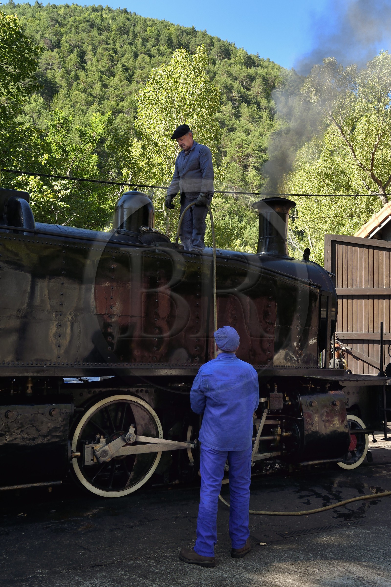 France, Alpes-Maritimes (06), Puget Théniers, le Train des Pignes, le chauffeur et le mécanicien font de l'eau pour la locomotive