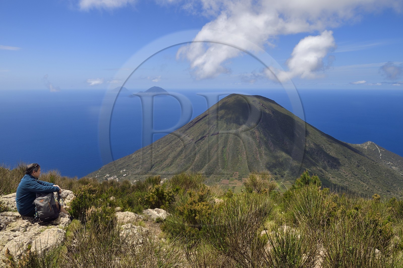 Italie, Sicile, iles Eoliennes, classées Patrimoine Mondial de l'UNESCO, Ile de Salina, randonneur au sommet de l'ancien volcan Monte Fossa delle Felci observant le volcan jumeau Monte dei Porri, les Iles de Filicudi et d'Alicudi en arrière plan