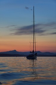 France, Var (83), Iles d'Hyères, parc national de Port Cros, Ile de Porquerolles, bateau au mouillage au crépuscule, la Presqu'Ile de Giens et le Mont Coudon en arrière plan