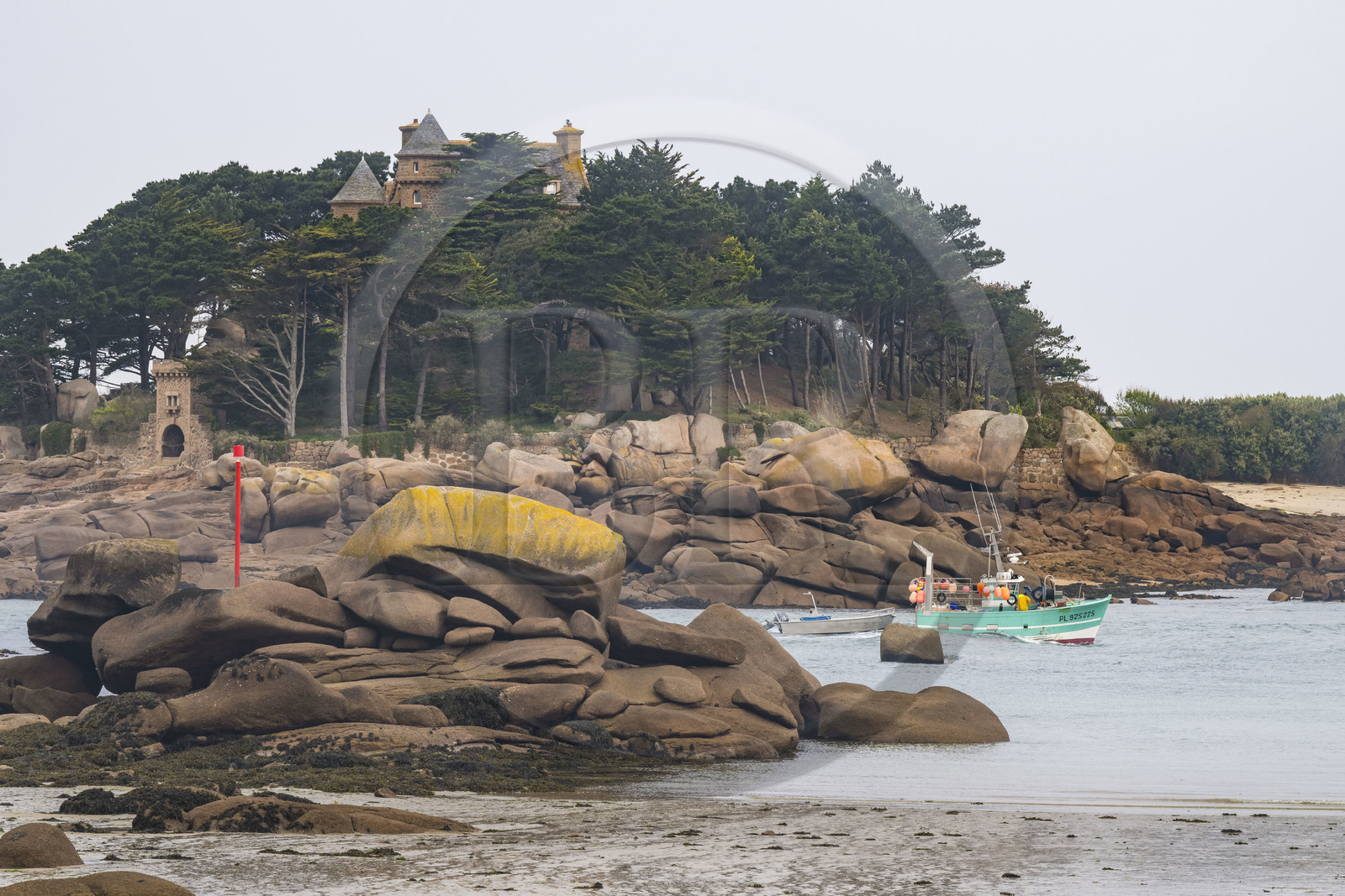 France, Côtes-d'Armor (22), Côte de Granit Rose, Perros-Guirec, bateau de pêche dans le chenal de sortie du port naturel de Ploumanac'h et le chateau de Costaérès sur son ile en arrière plan