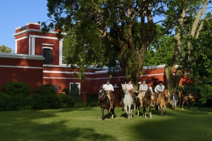 Argentine, province de Buenos Aires, San Antonio de Areco, groupe de gauchos à cheval devant l'estancia La Bamba de Areco