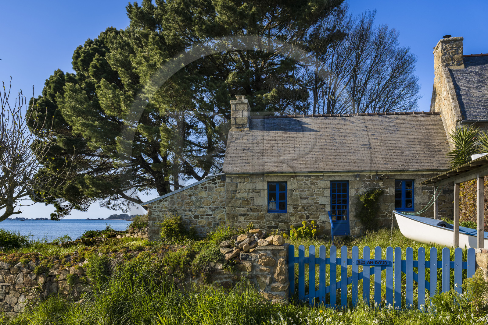 France, Côtes-d'Armor (22), Côte d'Ajoncs, Penvénan, fermette bretonne en granit avec son voilier remisé au jardin non loin du passage de Pellinec